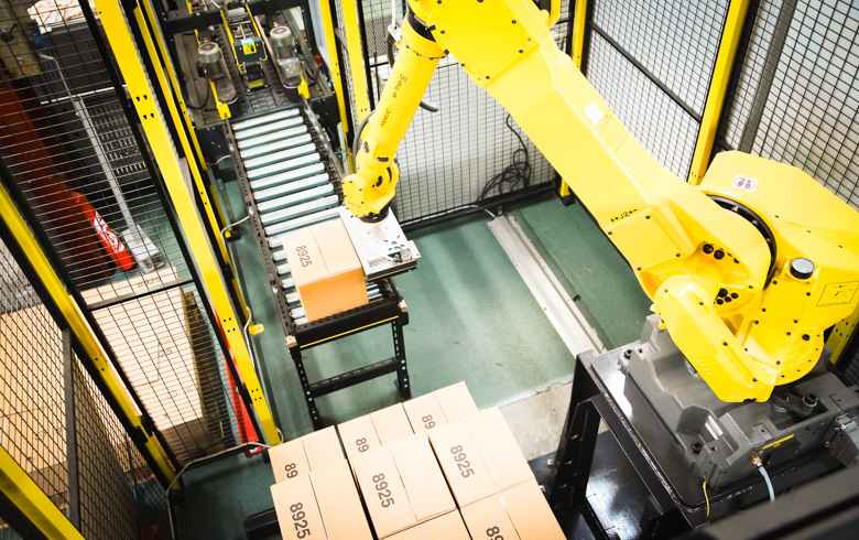 Robot palettiseur en train de prendre une caisse