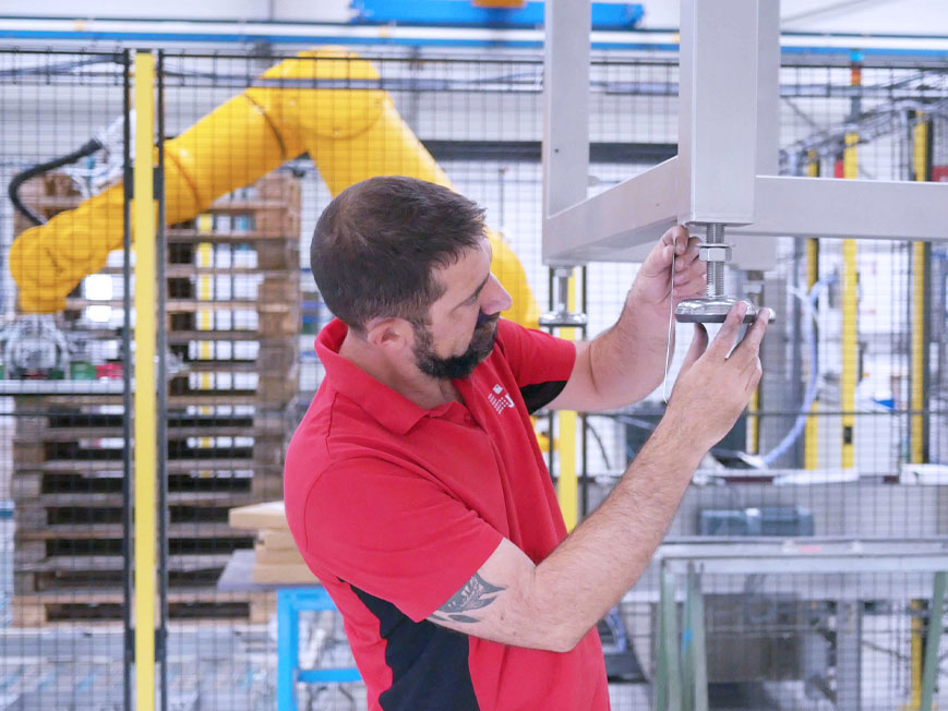 Monteur JYGA en atelier sur une machine de conditionnement de fin de ligne